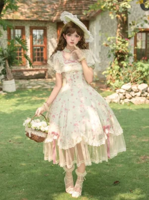 Front view of pink sweet lolita midi dress featuring ruffle collar and sheer tulle layered skirt with pink ribbon trims worn outdoors
