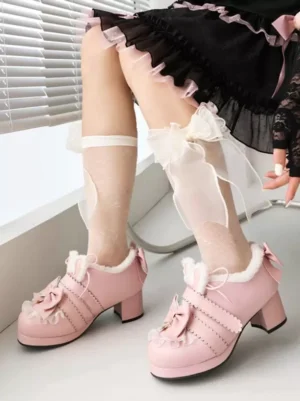 Pink sweet Lolita pumps side three-quarter view with plush rabbit ear trim, ruffled vamp, and chunky block heel worn with black lolita skirt and bow-decorated sheer socks