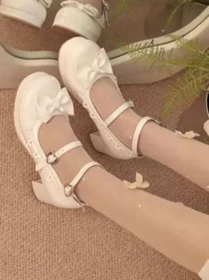 Sweet Lolita block heel pumps close-up worn on feet with sheer stockings showing front bow decoration and ankle buckle strap