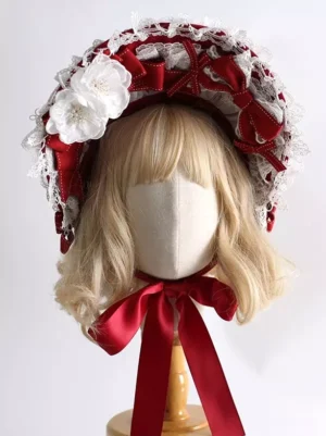 Sweet Lolita red and white bonnet hat with lace trim and satin bows displayed on mannequin with blonde wig, front-facing view showing delicate fabric flowers and romantic headdress design