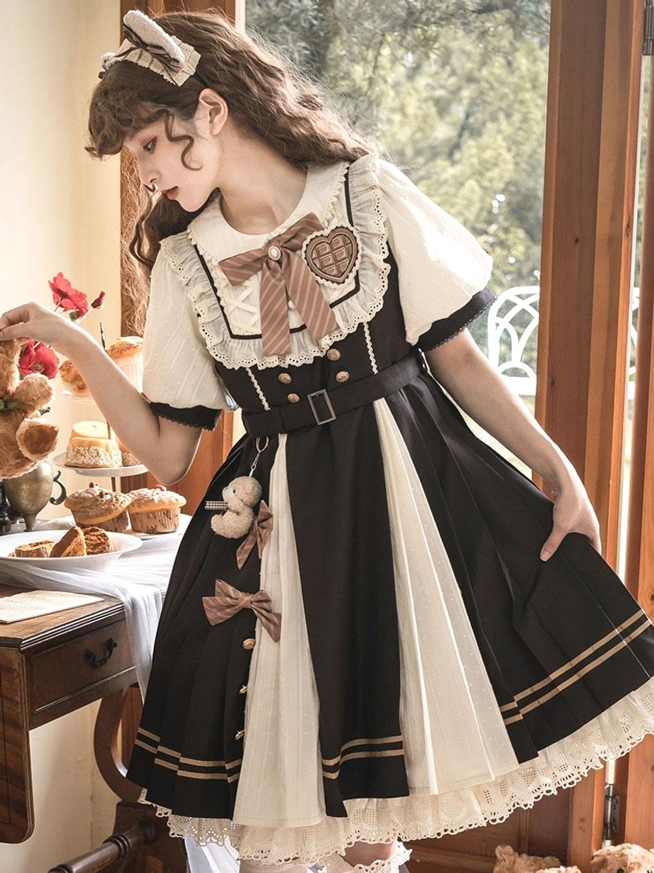 Sweet Lolita dress side profile showing pleated skirt and teddy bear pendant, styled with cat ear hairband and afternoon tea dessert backdrop