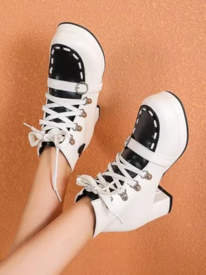 Sweet lolita round-toe ankle boots with white and black color block design, metal lace-up eyelets, chunky platform heel, and heart ornament detail displayed from top-down flat view