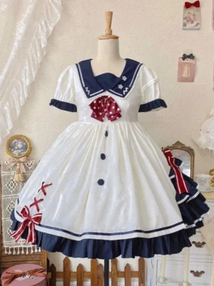 sweet lolita sailor dress front static view on dress form showing navy sailor collar cuffs red polka dot chest bow and layered navy ruffled hem with red ribbon