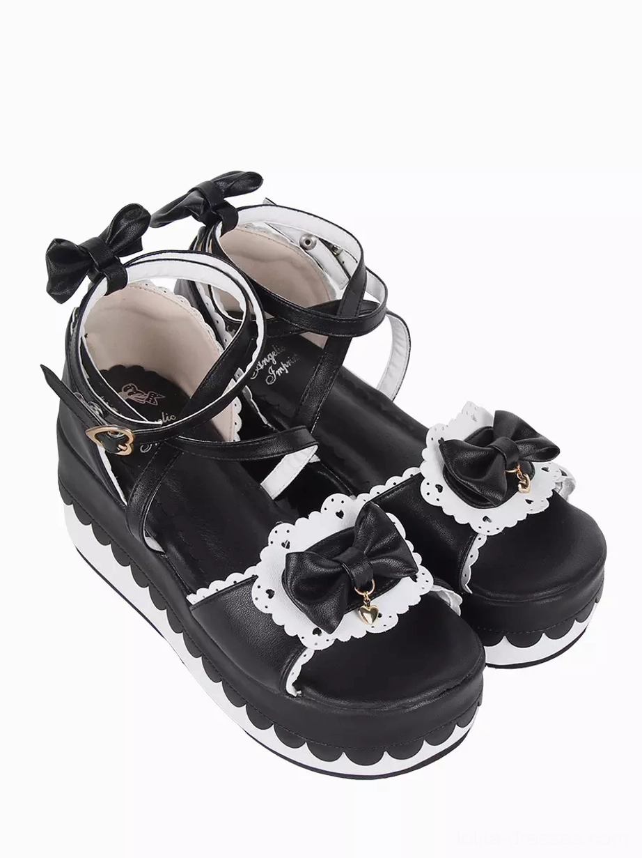 Sweet Lolita platform sandals rear three-quarter view displaying heart-shaped metal heel buckle, ankle strap, and light-colored PU lining detail on white background