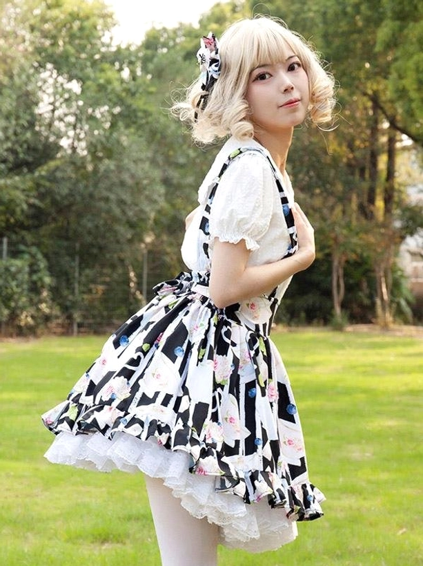 Lolita skirt with floral print and white ruffle underskirt, side three-quarter angle showing skirt volume and silhouette, outdoor lawn background