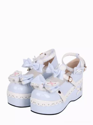 Light sky blue Sweet Lolita platform wedge pumps with white scalloped trim and bow decorations, front three-quarter view showcasing ankle buckle strap and decorative vamp bows