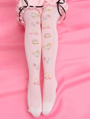 Sweet lolita knee-high socks with pastel pink tea party print featuring teacups and bows, worn with pink ruffled skirt and black bow details, styled on pink silk fabric backdrop