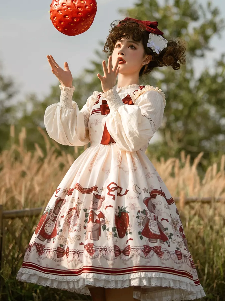 Sweet lolita jumper dress front three-quarter view grass field strawberry toss ruffled skirt