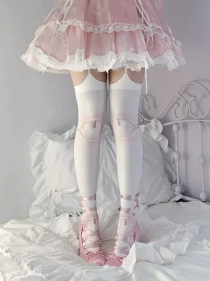 Sweet Lolita thigh-high stockings with pink knee patches worn with pink frilly mini skirt and pink bow heels, front low angle view