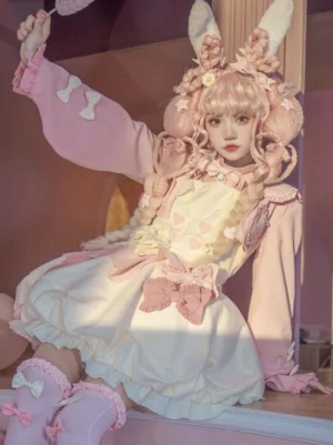 Sweet Lolita two-piece dress set front view with pink bolero and cream ruffled jumper skirt on model wearing bunny ear headbow