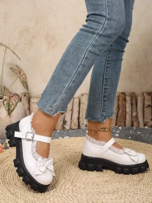 Sweet Lolita white chunky heel shoes side rear on-foot view displaying lace collar trim bow embellishment black platform sole worn with frayed jeans and ankle chain