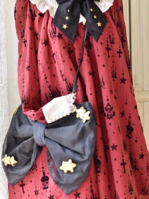 Sweet lolita white crossbody bag with gold star ornaments and dark grey chiffon bow styled with red gothic lolita dress featuring star prints left side view