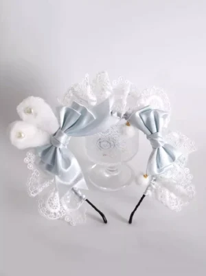 Pair of Sweet Lolita frilled headbands in white lace with blue satin bows and faux pearls shown in flat lay top-down view, displaying design details and accessories
