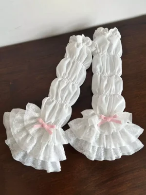 Sweet Lolita white oversleeves with pink velvet bow and layered lace ruffles flat lay display