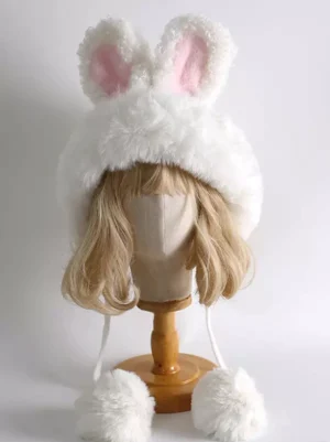 white rabbit ear plush lolita winter hat with pink inner ears front top view on mannequin with blonde wig showing fluffy pom-pom dangling straps