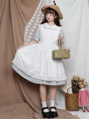 Sweet lolita white ruffled apron three-quarter front view with straw hat and black mary jane shoes vintage studio setting