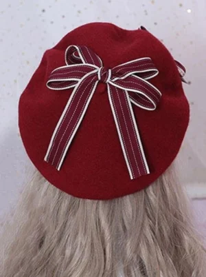 Overhead flat lay of sweet lolita beret showing burgundy solid wool color with double-striped ribbon bow embellishment and fuzzy wool texture detail
