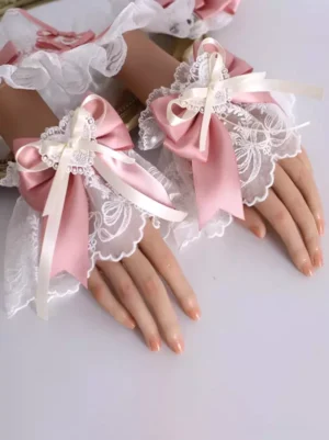 Sweet Lolita pink and white lace wrist cuffs with matching bow design featuring embroidered details and pearl accents shown from right oblique overhead angle