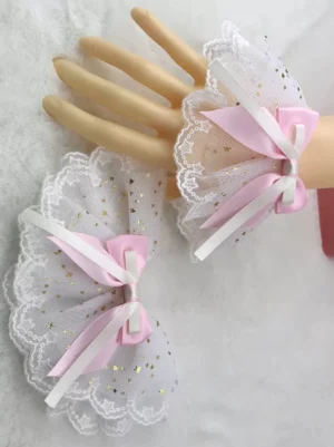Sweet Lolita wrist cuffs and pink satin hair bow set with white star-patterned ruffled mesh and gold foil details, featuring scalloped lace trim edge displayed on mannequin hands