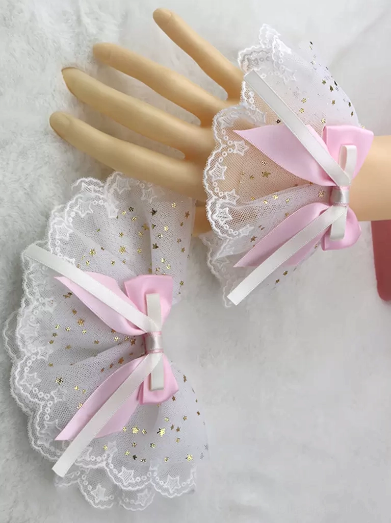 Sweet Lolita wrist cuffs and pink satin hair bow set with white star-patterned ruffled mesh and gold foil details, featuring scalloped lace trim edge displayed on mannequin hands