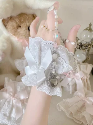 Sweet Lolita wrist oversleeves white satin bow eyelet lace ruffled edge close-up overhead view with plush toy accessories