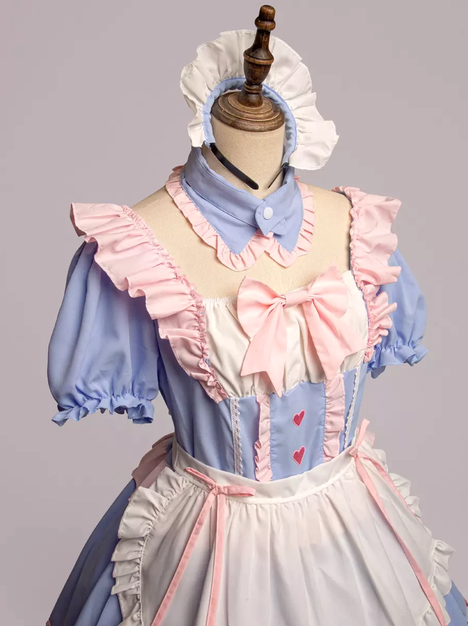 Close-up front detail of maid Lolita dress showing large pink bow and white ruffled apron panel