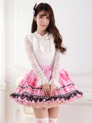 Female model wearing sweet pink lolita short skirt with clover print and black lace ruffle trim, paired with white lace blouse, front full-body view in minimalist white studio setting