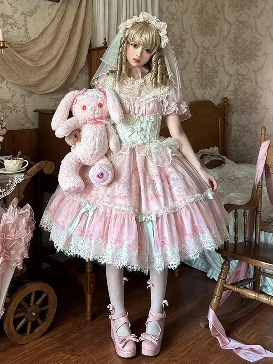 Sweet pink lolita dress with mint green bows full front view on model holding plush toy vintage bedroom scene