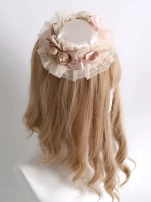 Rear top view of sweet pink lolita mini top hat with gold bell embellishments and layered tulle ruffles on mannequin with blonde wavy hair