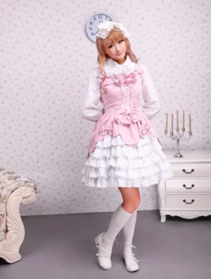 Sweet pink and white lolita jumper skirt front view on model in vintage bedroom setting, featuring lace-up corset bodice, tiered white ruffles, waist bowknot, paired with white socks and boots