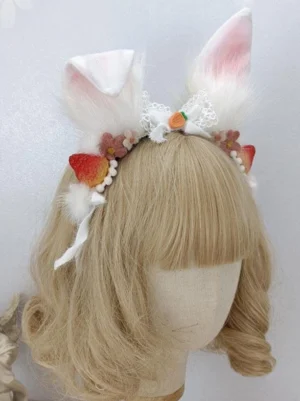 Sweet Rococo rabbit ear lolita headdress with white fuzzy ears pink inner linings lace bow strawberry carrot charms flower ornaments displayed on blonde bob wig mannequin three quarter angle view