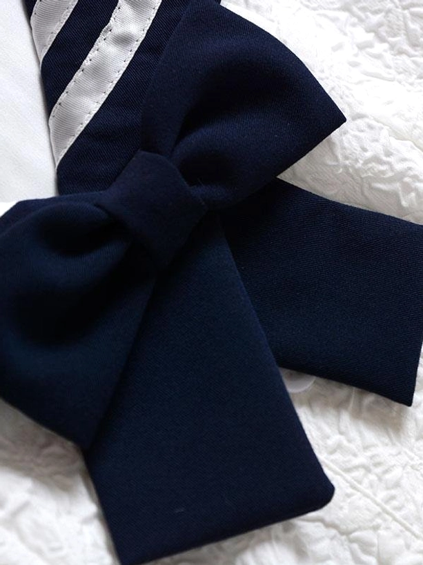 Close-up detail shot of detachable dark navy bow accessory for sweet sailor lolita dress showing large bow design and fabric construction