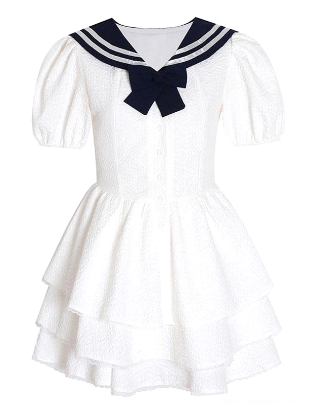 Flat lay product shot of sweet sailor lolita dress showing front navy bow collar puff sleeves embossed white fabric and tiered skirt construction detail