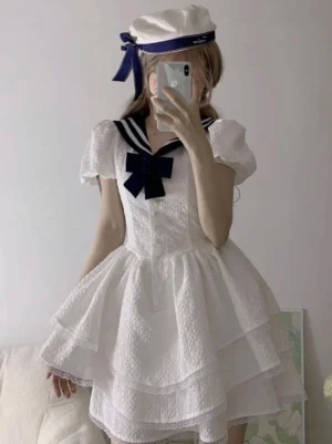 Sweet sailor lolita white dress with navy bow and puff sleeves worn by model in mirror selfie showing back view and ruffled skirt detail