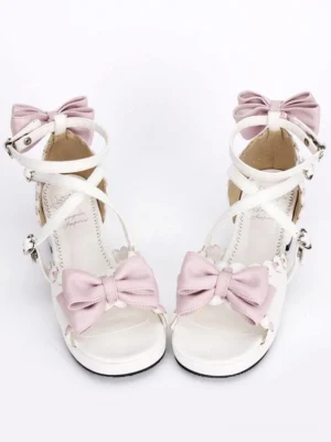 Sweet white Lolita block heel sandals with pink bows and heart-shaped buckles, front flat lay view showing cross ankle straps and open-toe design