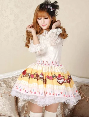 Sweet yellow Lolita cake skirt front three-quarter view with scalloped lace trim dessert print strawberry candy design worn on indoor sofa