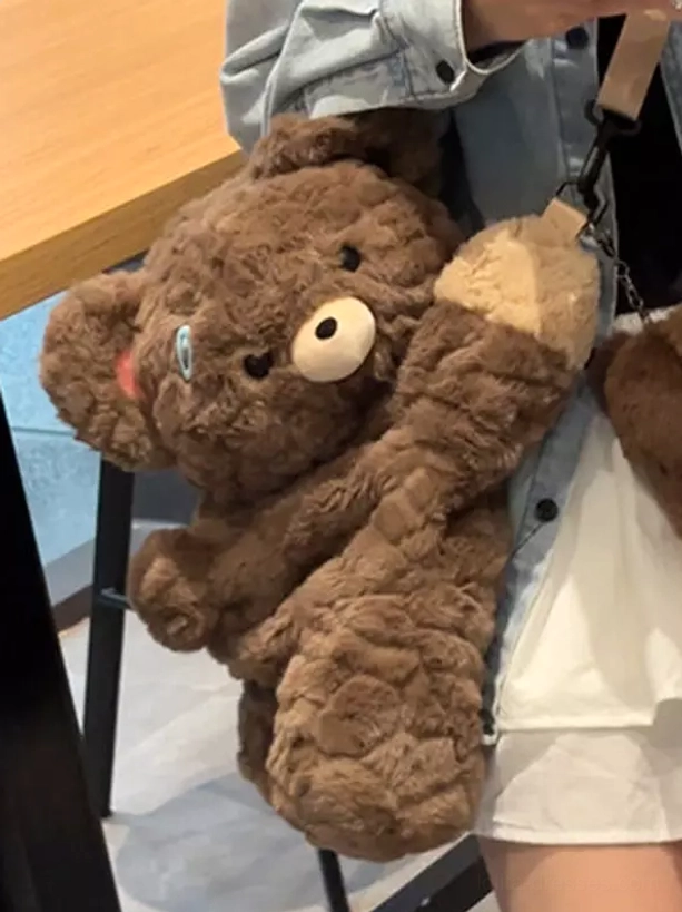 Close-up detail shot of quilted fuzzy dark brown corduroy teddy bear plush bag showing light beige paw pads and white nose features with beige strap