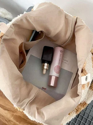 Interior view of fleece teddy bear tote bag showing beige polyester lining with skincare products, sweet lolita bag inside detail