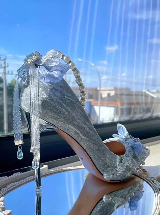 Back three-quarter view of glitter bridal pumps with long flowing tulle streamer bow pearl chain crystal heel accent and sparkle upper