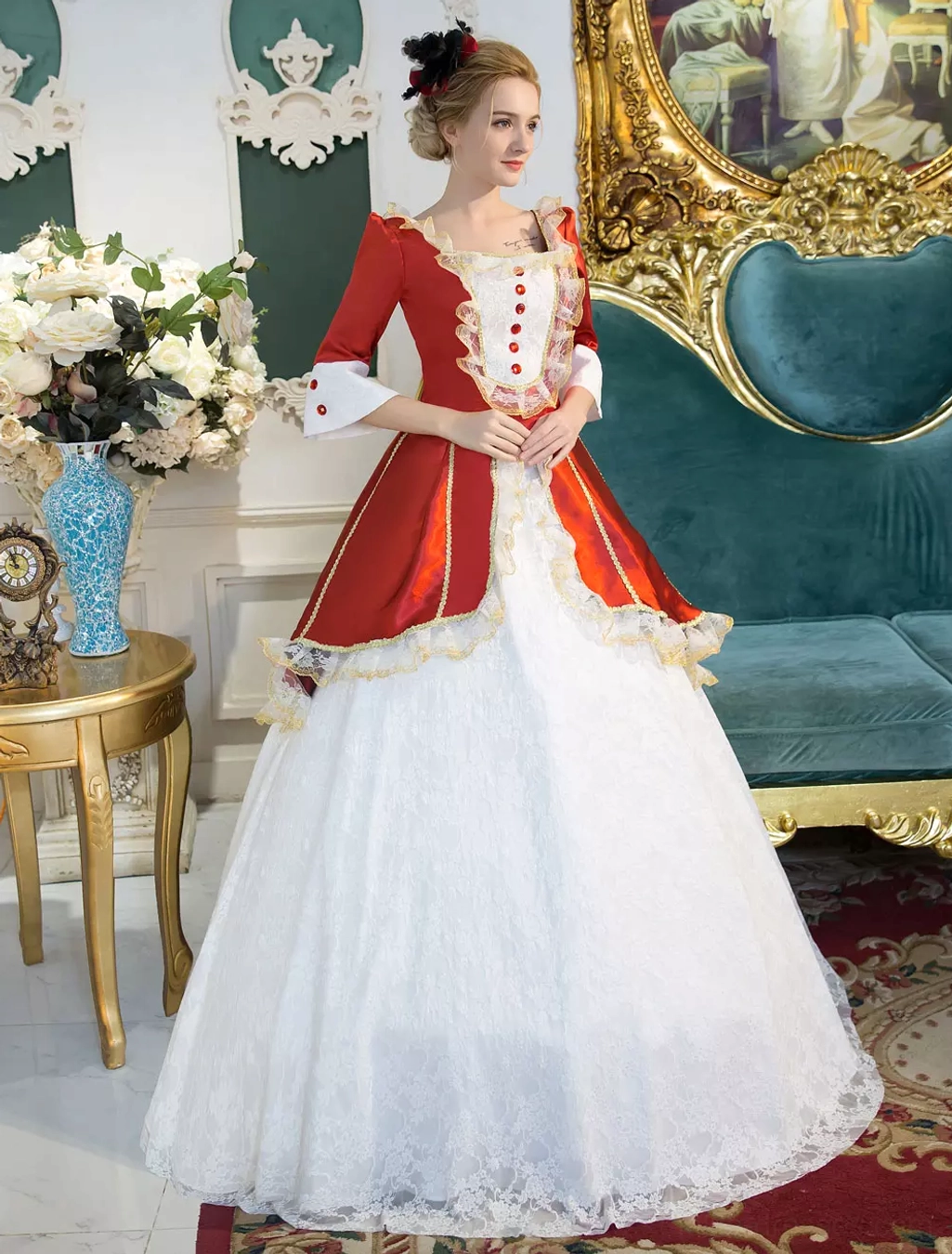 Victorian Lolita formal gown half front pose with hands folded, displaying floor-length white lace skirt with red satin waistband, square neckline, and structured silhouette in luxury vintage interior