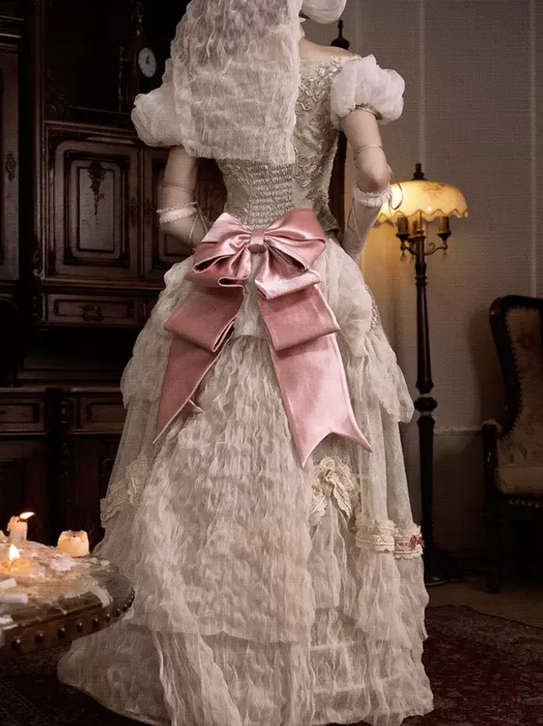Victorian lolita wedding dress rear back view with large pink satin bow ruffled layered bustle skirt and ornate veil headdress