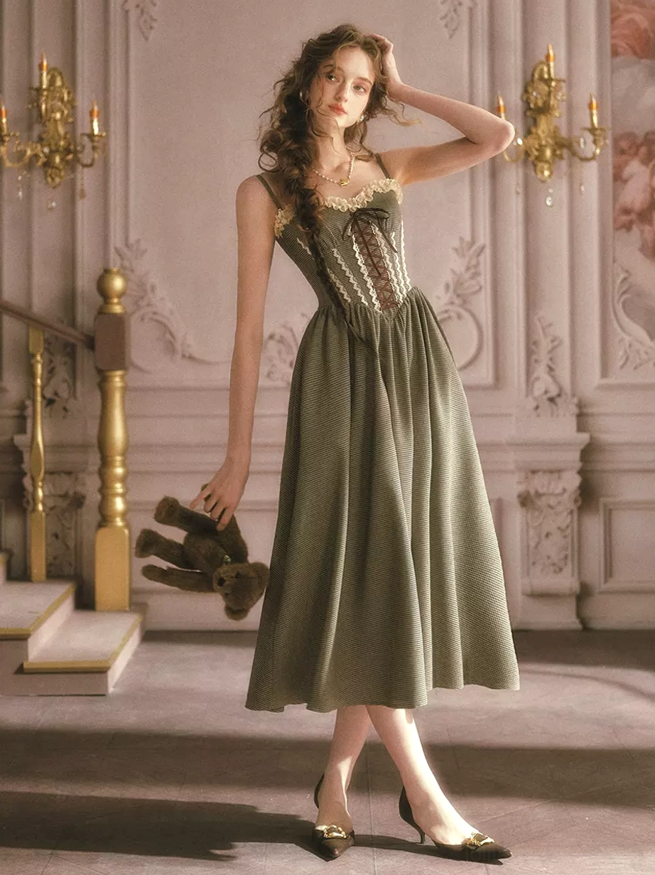 Sage green vintage corset fairy dress side view with teddy bear prop showing lace-up front bodice and midi swing skirt silhouette on model