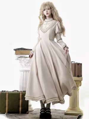 Vintage lolita empire waist dress with high neckline puff long sleeves front view on model in vintage prop scene featuring golden chest embroidery and refined classic silhouette