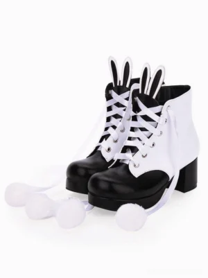 White and black two-tone gothic Lolita ankle boots with bunny ear toppers, fluffy pom-poms, lace-up closure, and block high heel front three-quarter angle