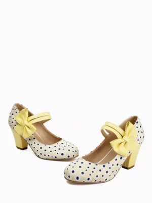 Pair of white and blue polka dot Mary Jane lolita shoes with yellow bow straps and block heels - flat lay product shot