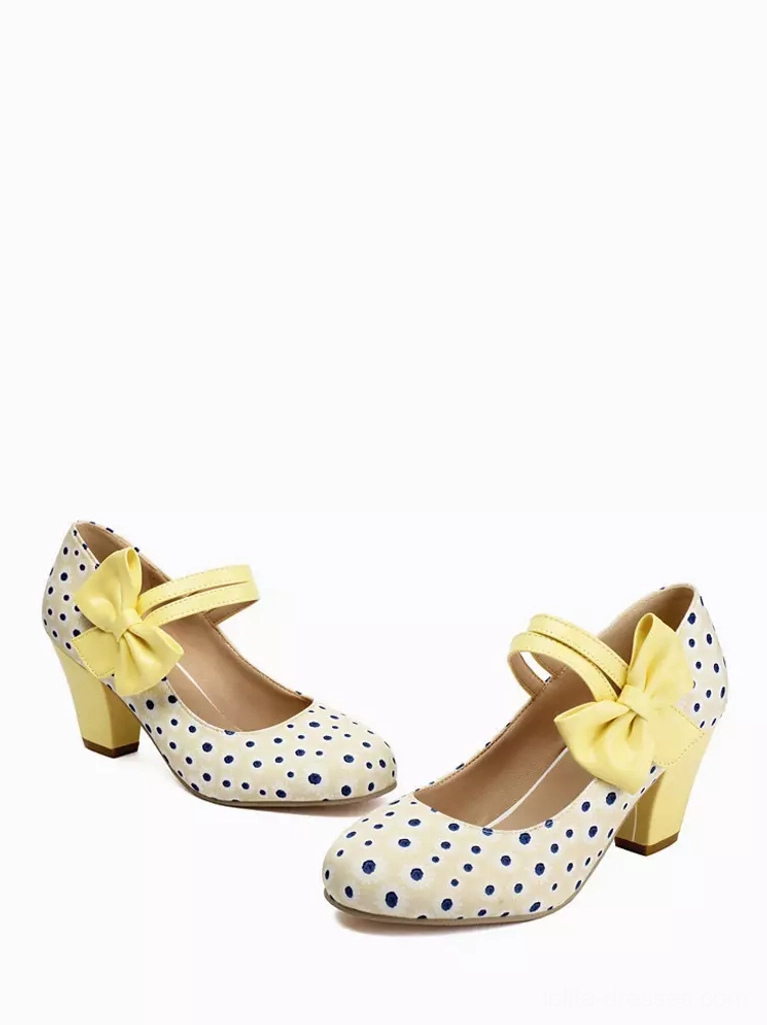 Pair of white and blue polka dot Mary Jane lolita shoes with yellow bow straps and block heels - flat lay product shot