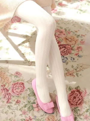white-knit-heart-pattern-lolita-tights-low-side-close-up-view-with-pink-bow-flat-shoes-on-floral-carpet
