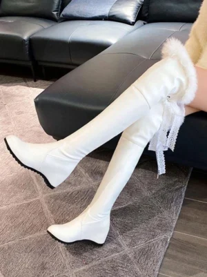 elegant over-knee lolita boots featuring white faux leather white fluffy fur trim and back lace tassel detail worn seated