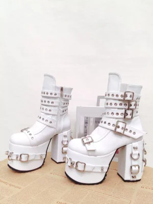 White gothic lolita platform boots with silver hardware buckles and thick platform heel displayed on vintage newspaper backdrop, demonstrating elegant colorway option