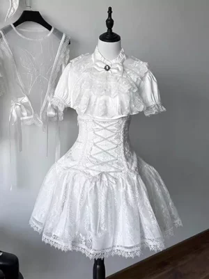 White gothic lolita dress set front view on mannequin featuring structured corset lace-up waist, delicate lace capelet collar with bow brooch accent, short sleeves, and ruffled lace-trimmed mini skirt - authentic japanese lolita fashion